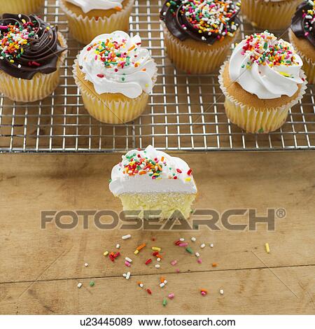 Stock Photo - Homemade cupcakes, one with missing bite. Fotosearch