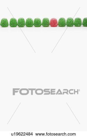 Picture - Line of green jellies and one red. Fotosearch