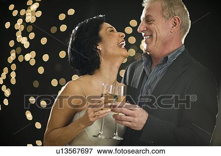 Stock Photo - Mature couple toasting with champagne. Fotosearch