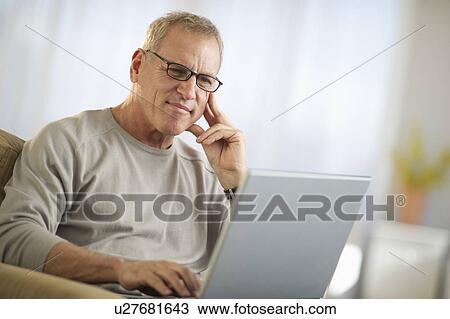 Stock Image - Mature man working on laptop. Fotosearch