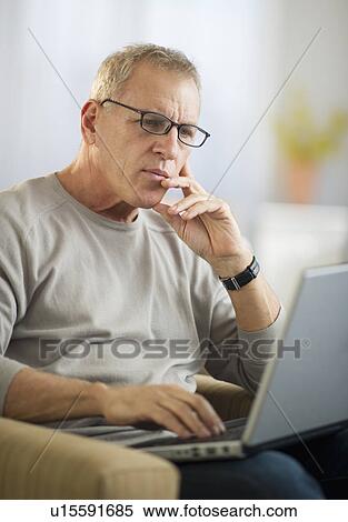 Stock Photography - Mature man working on laptop. Fotosearch