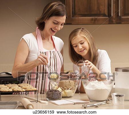 Stock Photo - Mother baking with daughter (10-11) in kitchen. Fotosearch