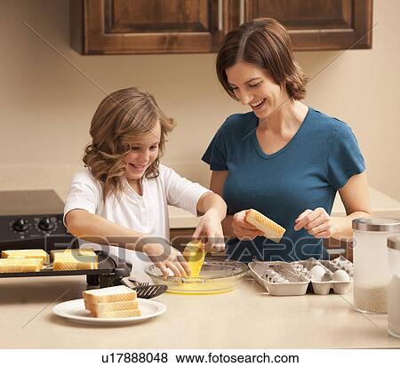 Mother preparing breakfast with daughter (10-11) in kitchen View Large Photo Image Stock Photo - Mother preparing breakfast with daughter (10-11) in kitchen. Fotosearch