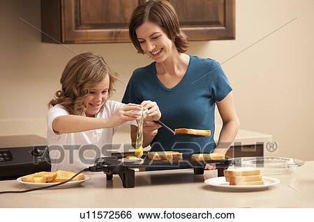 Mother preparing breakfast with daughter (10-11) in kitchen View Large Photo Image Stock Photograph - Mother preparing breakfast with daughter (10-11) in kitchen. Fotosearch