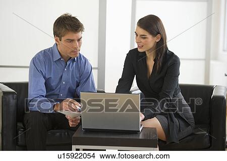 Picture - Pair of businesspeople working in office. Fotosearch