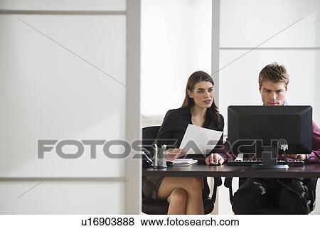 Pair of businesspeople working in office View Large Photo Image Stock Photo - Pair of businesspeople working in office. Fotosearch