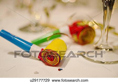Party horn blower and champagne flute on table, close-up View Large Photo Image Stock Photo - Party horn blower and champagne flute on table, close-up. Fotosearch