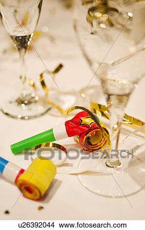 Party horn blowers and champagne flutes on table, close-up View Large Photo Image Picture - Party horn blowers and champagne flutes on table, close-up. Fotosearch