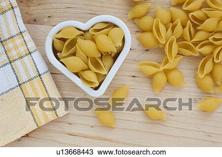 Stock Image - Pasta in heart shaped bowl. Fotosearch