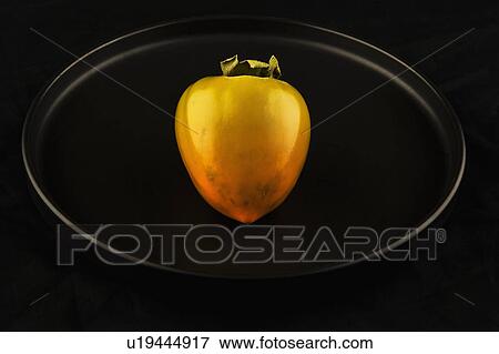 Stock Photo - Persimmon on black background. Fotosearch