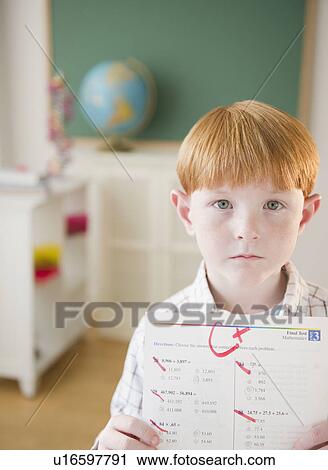 Portrait of boy (8-9) holding test results in classroom View Large Photo Image Stock Image - Portrait of boy (8-9) holding test results in classroom. Fotosearch