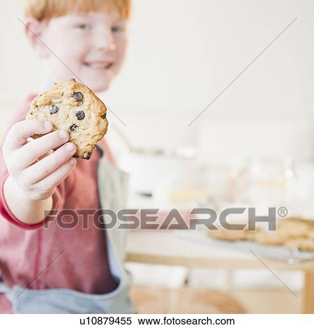 Stock Photography - Portrait of boy (8-9) showing cookie. Fotosearch