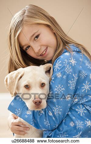 Stock Photo - Portrait of girl (10-11) embracing Labrador . Fotosearch