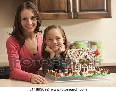 Portrait of two sisters (6-7, 18-19) by gingerbread house View Large Photo Image Stock Image - Portrait of two sisters (6-7, 18-19) by gingerbread house. Fotosearch