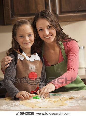 Portrait of two sisters (6-7, 18-19) making cookies View Large Photo Image Stock Photo - Portrait of two sisters (6-7, 18-19) making cookies. Fotosearch