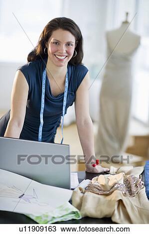 Stock Image - Portrait of young fashion designer at work. Fotosearch