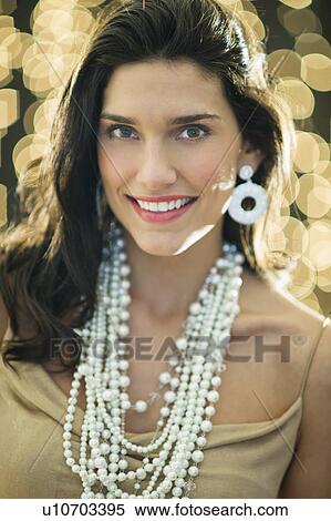 Stock Photography - Portrait of young happy woman wearing jewelry. Fotosearch