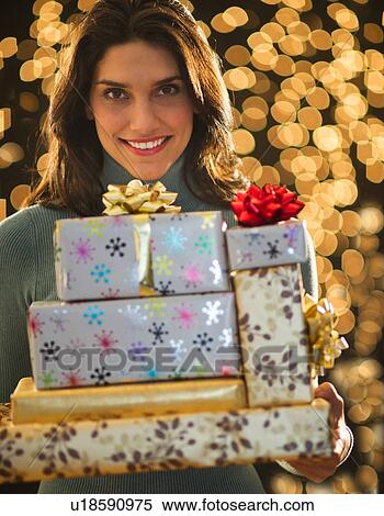 Portrait of young woman carrying Christmas presents View Large Photo Image Stock Photography - Portrait of young woman carrying Christmas presents. Fotosearch