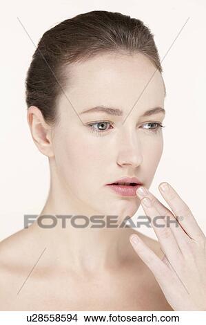 Picture - Portrait of young woman touching lips. Fotosearch