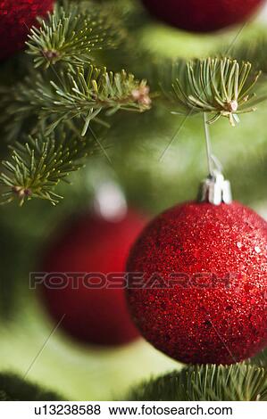 Stock Photo - Red Christmas baubles on tree. Fotosearch