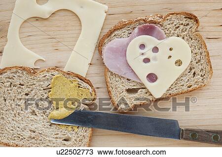 Stock Image - Sandwich with heart shaped slices of meat and cheese. Fotosearch