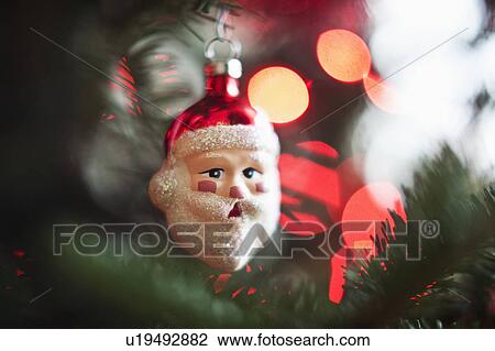 Stock Image - Santa Claus Christmas decoration hanging on Christmas tree, studio shot. Fotosearch