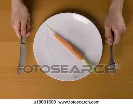 Stock Image - Single carrot on white plate. Fotosearch