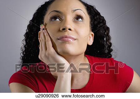 Studio portrait of young woman looking up View Large Photo Image Stock Photograph - Studio portrait of young woman looking up. Fotosearch