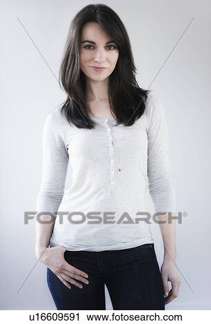 Stock Image - Studio portrait of young woman smiling. Fotosearch