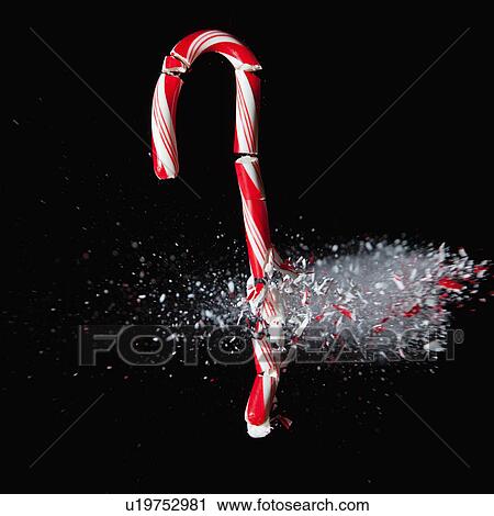Stock Image - Studio Shot of candy cane crushed by bullet. Fotosearch