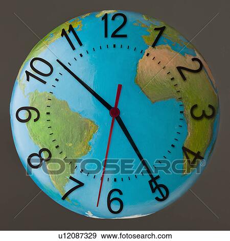 Stock Photo - Studio Shot of clock embedded in globe. Fotosearch