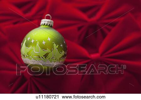 Stock Image - Studio Shot of red velvet bows with green Christmas ornament. Fotosearch