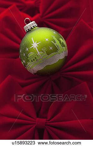Stock Image - Studio Shot of red velvet bows with green Christmas ornament. Fotosearch