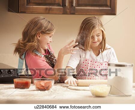 Two girls (10-11) preparing pizza in kitchen View Large Photo Image Picture - Two girls (10-11) preparing pizza in kitchen. Fotosearch