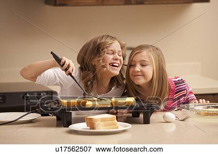 Two girls (10-11) preparing toast in kitchen View Large Photo Image Stock Photo - Two girls (10-11) preparing toast in kitchen. Fotosearch