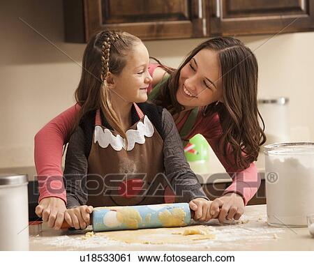 Two sisters (6-7, 18-19) rolling dough View Large Photo Image Stock Image - Two sisters (6-7, 18-19) rolling dough. Fotosearch
