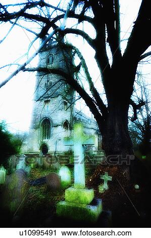 Stock Image - United Kingdom, Bristol, Trees and gravestones outside church. Fotosearch