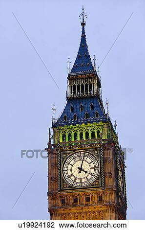 Stock Image - United Kingdom, London, Big Ben clock face illuminated at dusk. Fotosearch