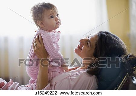 USA, California, Berkeley, Mother holding baby girl (6-11months) on sofa View Large Photo Image Stock Image - USA, California, Berkeley, Mother holding baby girl (6-11months) on sofa. Fotosearch