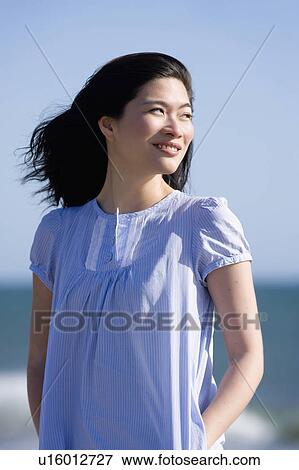 Stock Photo - USA, California, Point Reyes, Pensive young woman at coast. Fotosearch
