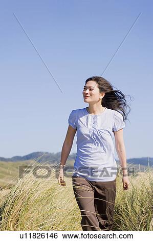 USA, California, Point Reyes, Young woman walking in grass View Large Photo Image Stock Photograph - USA, California, Point Reyes, Young woman walking in grass. Fotosearch