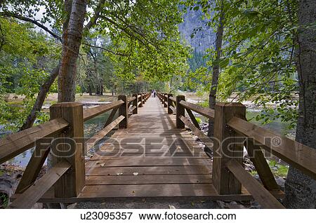 Stock Photo - USA, California, wooden footbridge on Merced River. Fotosearch