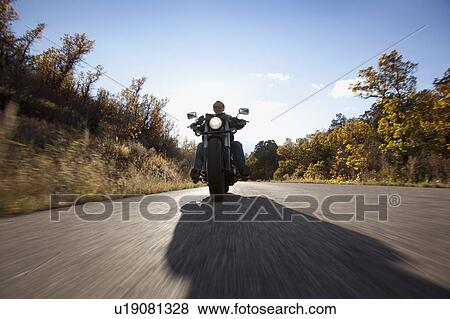 Stock Photo - USA, Colorado, Carbondale, Mature man driving motorcycle. Fotosearch