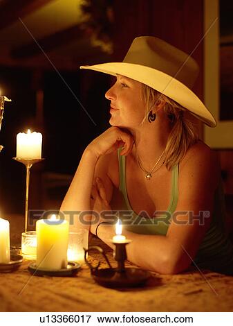USA, Colorado, Cowgirl sitting at table with candles View Large Photo Image Stock Photo - USA, Colorado, Cowgirl sitting at table with candles. Fotosearch