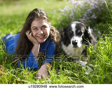 USA, Colorado, Portrait of young woman relaxing with dog on grass View Large Photo Image Stock Photo - USA, Colorado, Portrait of young woman relaxing with dog on grass. Fotosearch