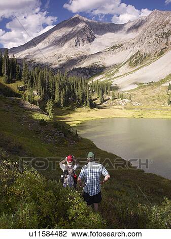 Stock Image - USA, Colorado, Senior couple hiking in mountains. Fotosearch