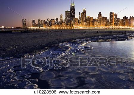 Stock Photograph - USA, Illinois, Chicago, City skyline from Lake Michigan at sunset. Fotosearch