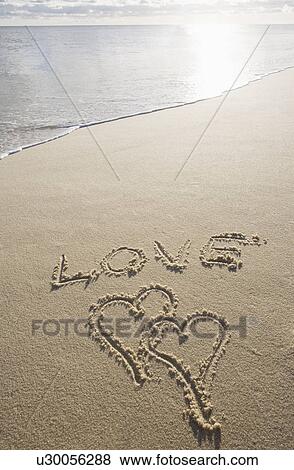 Stock Photo - USA, Massachusetts, love sign with heart shapes on sand. Fotosearch
