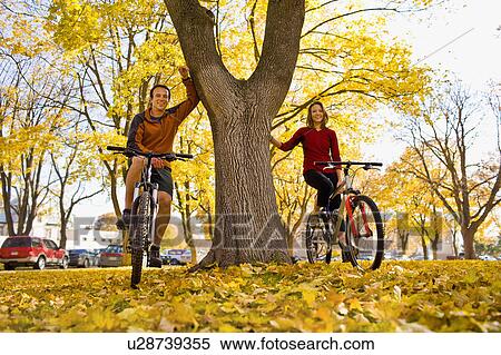 Stock Photography - USA, Montana, Kalispell, Portrait of couple at bikes in park. Fotosearch