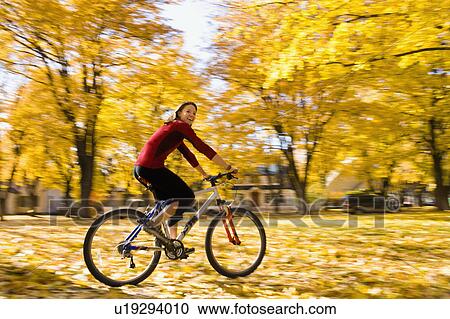 USA, Montana, Kalispell, Young woman cycling in park View Large Photo Image Stock Image - USA, Montana, Kalispell, Young woman cycling in park. Fotosearch